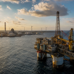 Plataforma de petróleo em alto-mar ao lado de equipamentos industriais de energia, sem textos ou logotipos visíveis