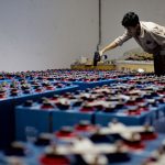 Trabalhador verifica um conjunto de baterias industriais dentro de uma instalação de armazenamento de energia.