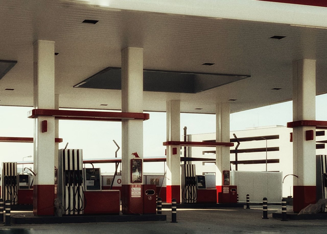 Posto de combustíveis moderno com várias bombas de abastecimento iluminadas.
